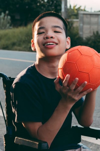 Child on a wheelchair playing basketball