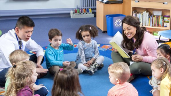 Group of kids sitting in a circle with teachers