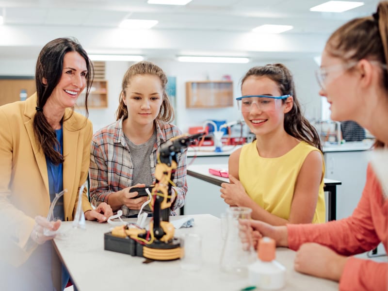 Young girls with teacher in robotics lab