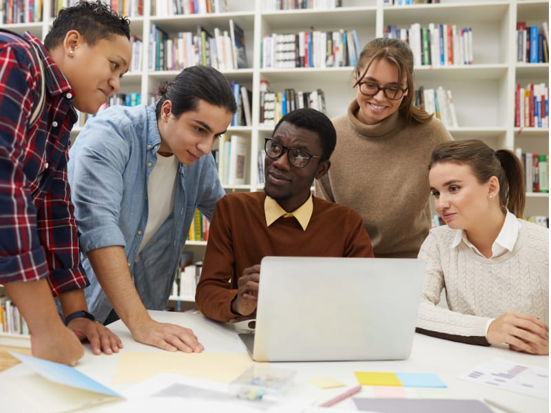 Group of students looking at a laptop